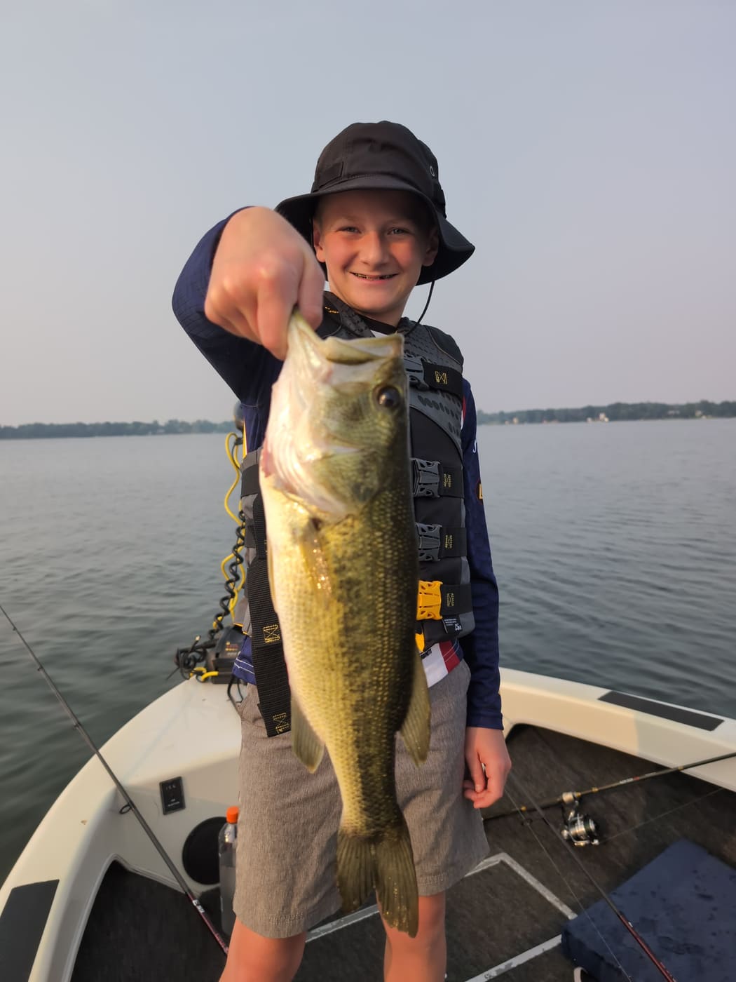 Young angler holding a giant largemouth at dusk